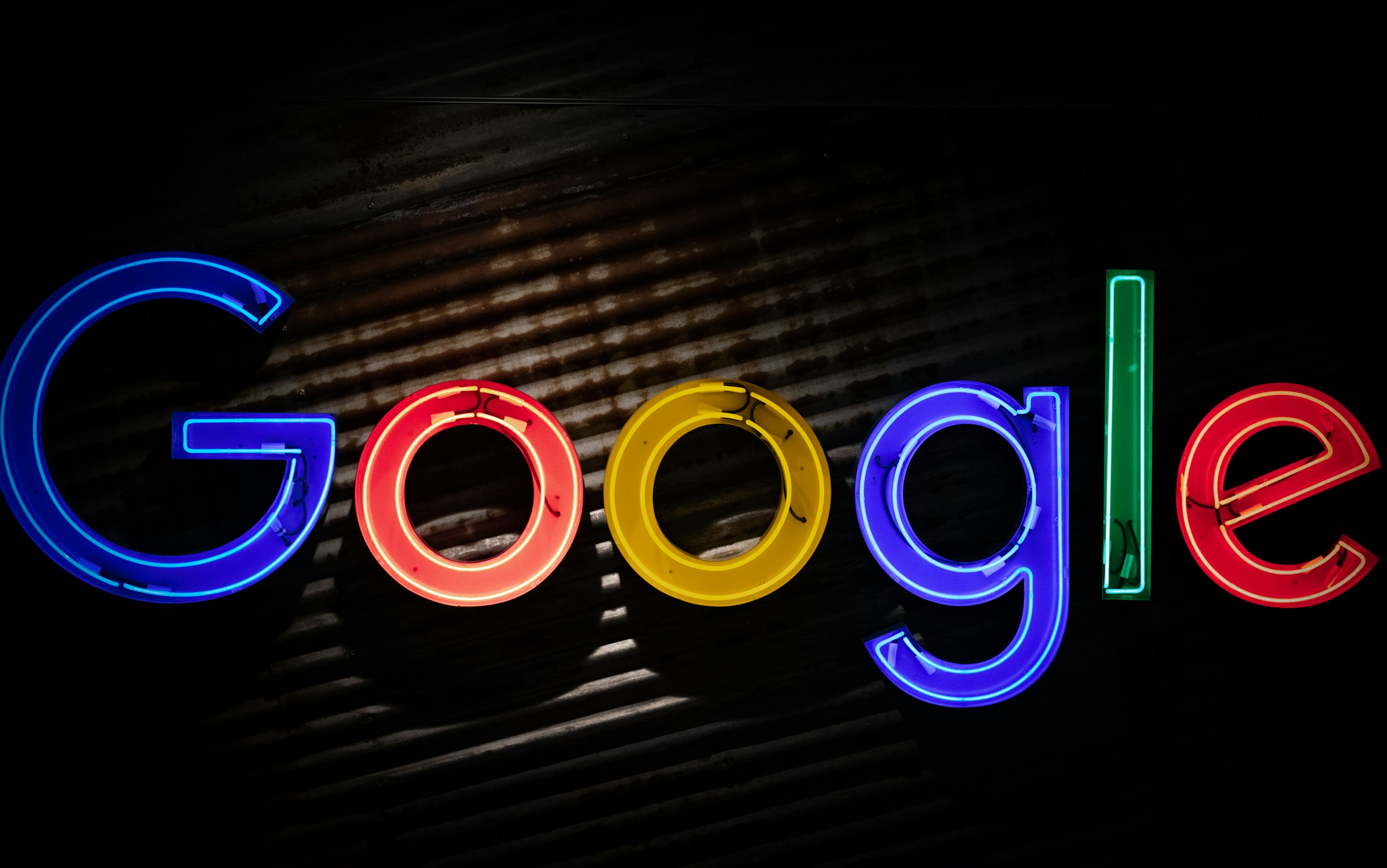 Google logo neon sign as the company announces a restructuring of its divisions and leadership to accelerate its AI initiatives.